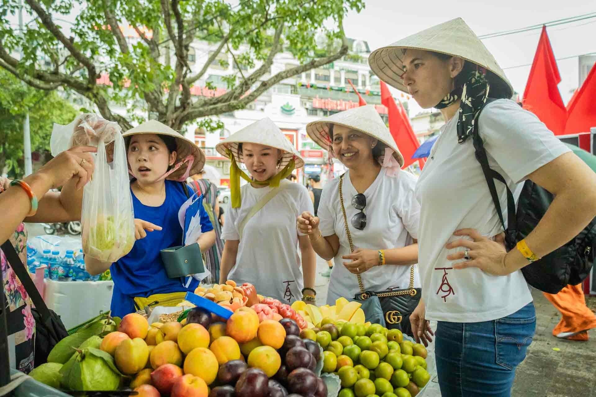 Travellers buying fruit in 3 day itinerary hanoi - Jackfruit Adventure
