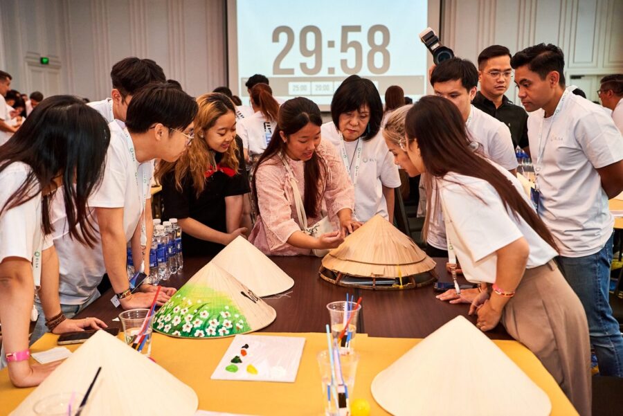 Corporate team participating in a creative workshop decorating conical hats during team bonding activities_unique-team-building-activities-vietnam_jackfruit-adventure