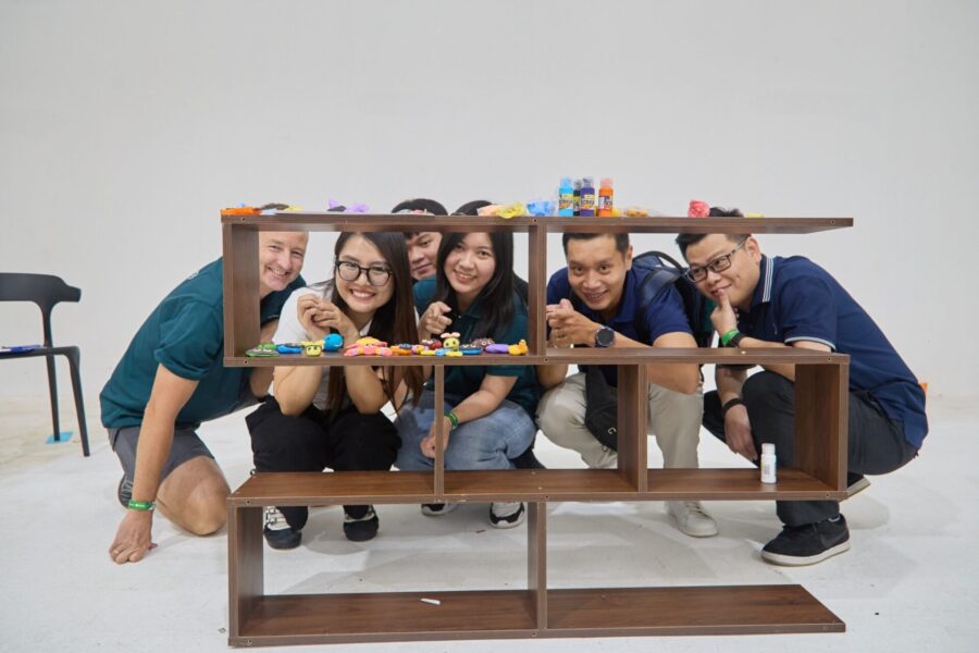 Corporate team bonding activities during a creative shelf building challenge, focusing on collaboration and teamwork.