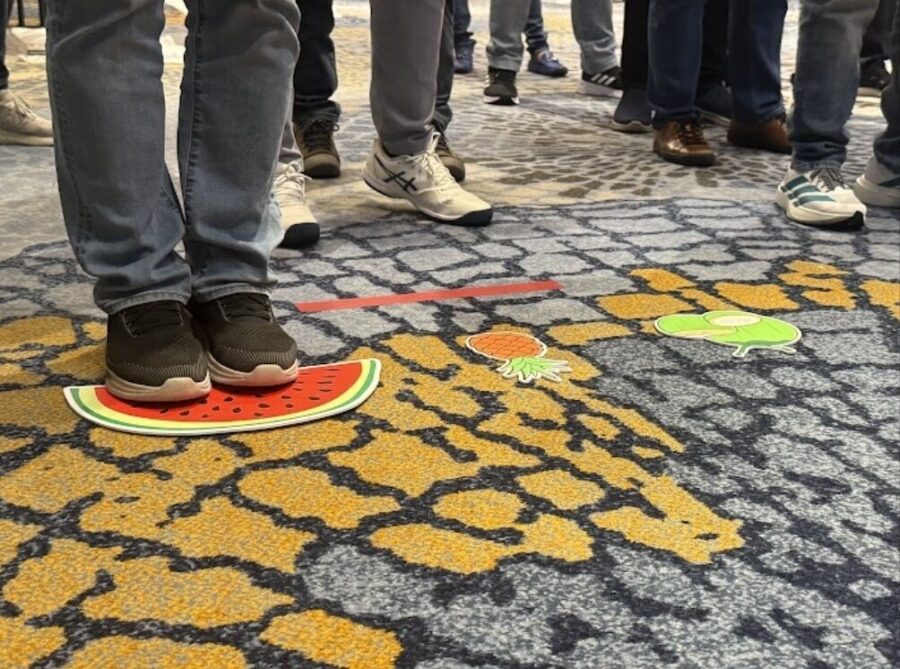 Corporate team bonding activities during a fruit path coordination challenge, focusing on teamwork and communication.