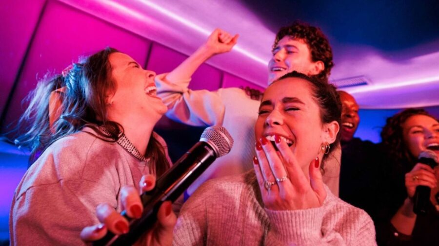 Friends laughing and singing together during karaoke in Ho Chi Minh City.