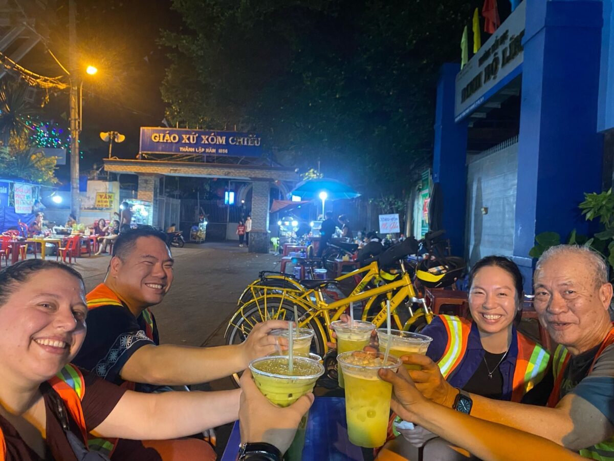 Guests toast with fresh drinks at a night street food stop during one day in Ho Chi Minh City - Jackfruit