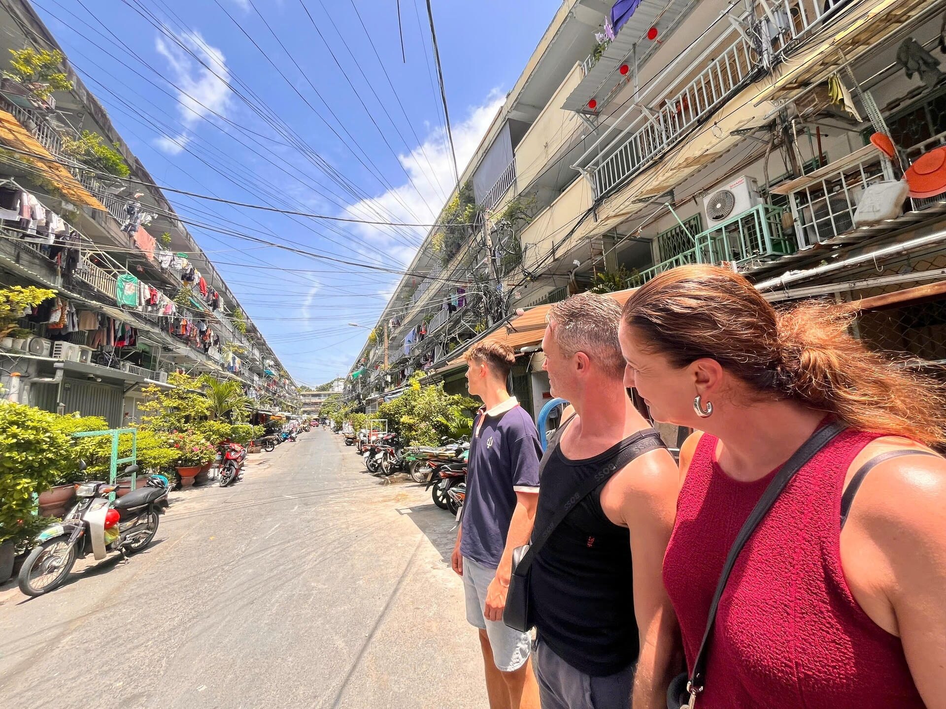 the family cycling past the Nguyễn Thiện Thuật apartment block
