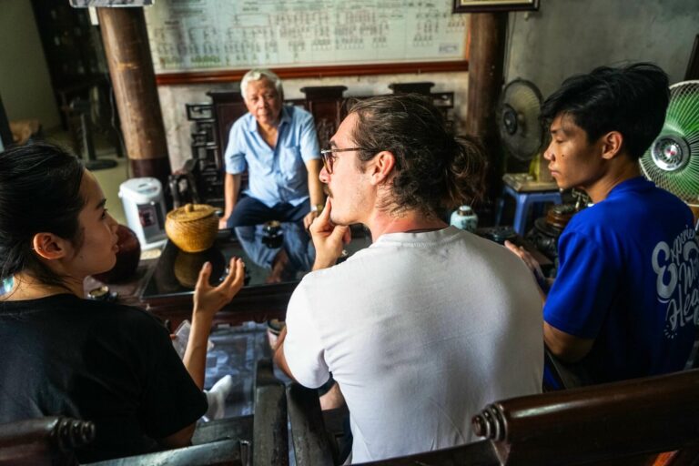 Traveler practicing basic Vietnam language phrases with a local vendor, guided by Jackfruit Adventure